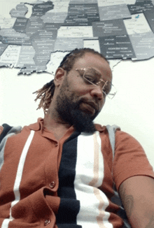 a man in a striped shirt is sleeping in front of a map of the united states of america