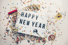 a happy new year sign is surrounded by confetti and streamers