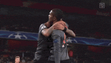 two t-mobile soccer players are hugging each other on the field