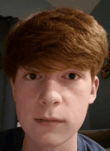 a close up of a boy 's face with a blue shirt on