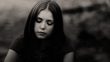 a black and white photo of a young woman with her eyes closed .