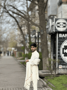 a man standing in front of a sign that says ks on it