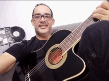 a man is holding a guitar in front of a record that says eddy lira