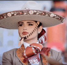 a woman wearing a sombrero has a scarf around her neck that says " noting "