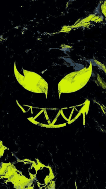 a yellow pumpkin face with sharp teeth on a black background