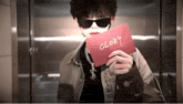 a man wearing sunglasses is holding a red card with the word glory written on it