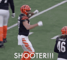 a group of football players are standing on a field with the words `` shooter '' written on the ground .