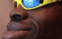 a close up of a person 's face wearing sunglasses .