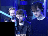 a man wearing headphones stands in front of a microphone with the word lovejoy on the bottom left