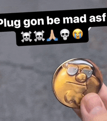 a person is holding a coin with a smiley face on it in front of a sign that says plug gon be mad ass