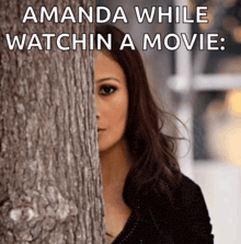 a woman peeking out from behind a tree with a caption that says amanda while watchin a movie