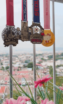 several medals are hanging on a railing including one that says seoul