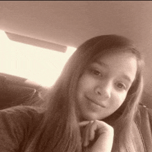 a young girl with long hair is sitting in a car