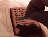 a person is using a knife to cut a piece of clay