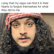 a man with curly hair and a beard is wearing a red and white scarf around his head