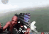 a shirtless man is holding a microphone with the word aspesse on the bottom right