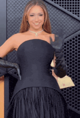 a woman in a black dress and black gloves