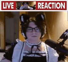 a man in a maid costume is sitting in front of a microphone with the words live reaction above him