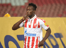 a man wearing a red and white striped shirt with gazprom on it