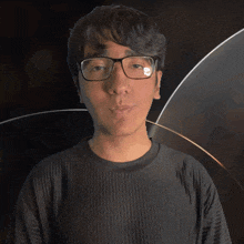 a man wearing glasses and a black shirt with the word sam on it