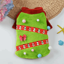 a green and red christmas sweater with snowmen and pom poms