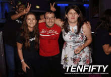 a man wearing a jiu-jitsu shirt poses with two girls