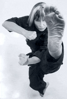 a black and white photo of a woman kicking her foot in the air