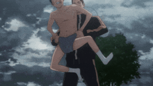 a shirtless man is carrying another shirtless man in shorts