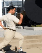 a man in a white shirt and khaki pants is running down the street