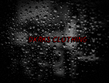 a black background with water drops and the words dxrks clothing in red