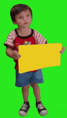 a young boy in a red and white striped shirt holds a yellow sign