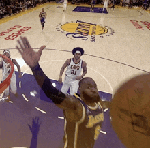 a basketball player wearing a cavs jersey goes up for a dunk