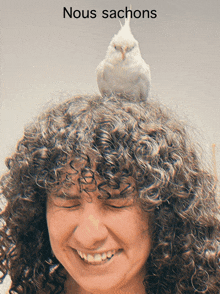 a woman with curly hair has a bird on her head and the words nous sachons above her head