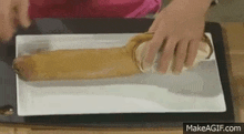 a person is holding a sandwich on a white plate .