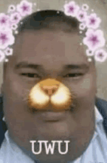 a man is wearing a cat mask with flowers on his nose .