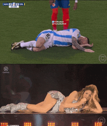 a soccer player laying on the field next to a woman