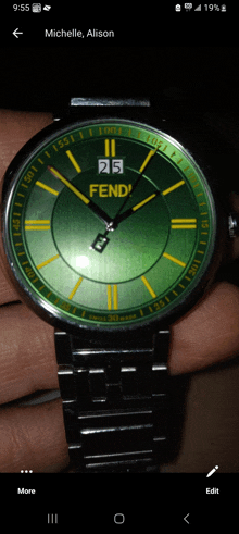 a person is holding a green and yellow fendi watch