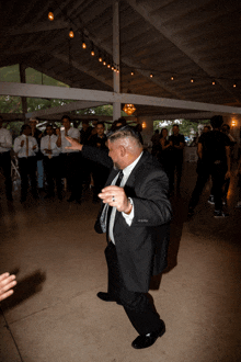 a man in a suit and tie is dancing in a crowd