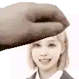 a hand is holding a woman 's head and smiling .