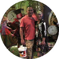 a man and woman pose for a picture in front of a clock