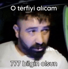 a man with a beard is sitting in a car with the words o terfiyi alicam 777 bilgin olsun written below him