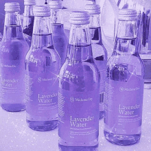 a group of bottles of lavender water are lined up on a table .