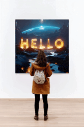 a woman looking at a painting that says hello on it