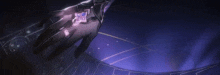 a close up of a person 's hand holding a purple object in the dark .