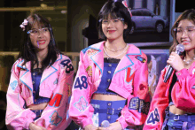 three girls wearing pink jackets with 48 on them