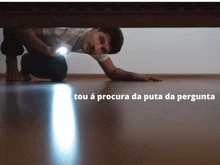 a man is crawling under a bed with a flashlight and the words tou a procura da puta da pergunta above him