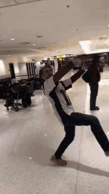 a man taking a picture of himself in an airport while wearing a jersey with the number 1 on it