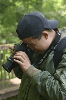 a man taking a picture with an eos digital camera strap