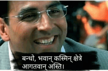 a man wearing glasses and a suit is smiling with a caption in a foreign language