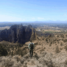 a man with a backpack is standing on top of a hill